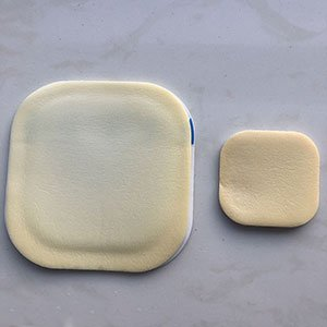 Adhesive foam wound dressing