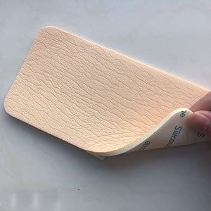 Adhesive foam wound dressing